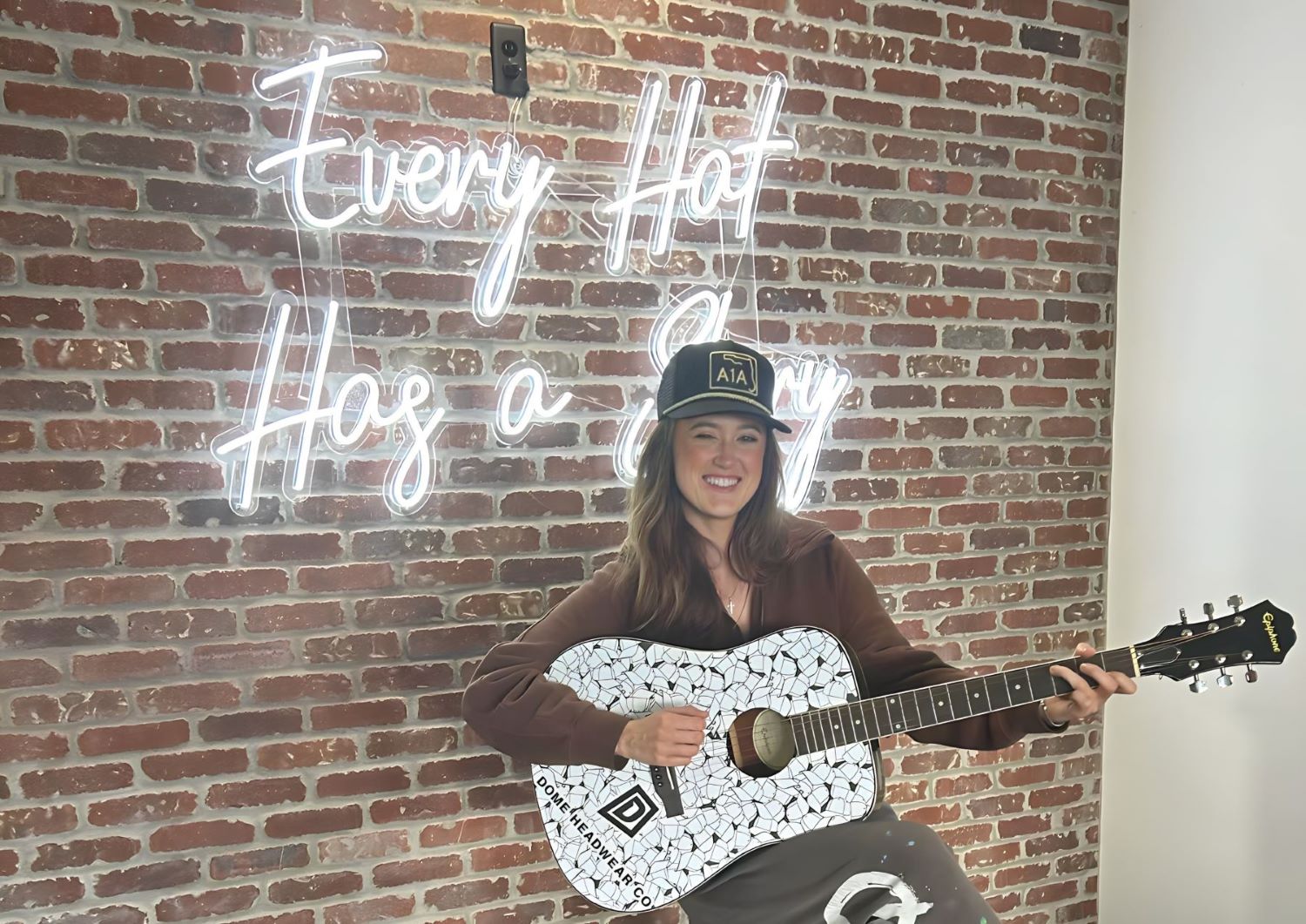 Every Hat Has a Story white Custom Neon® tagline sign on brickwall @domehats