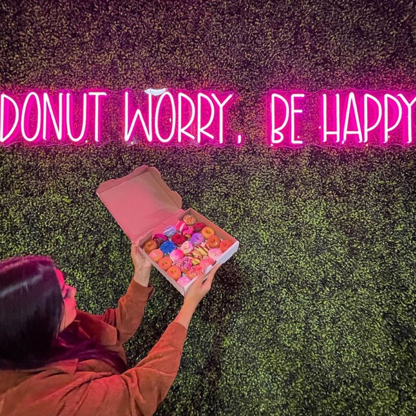 Custom Neon® pink selfie sign on grasswall @getminidonuts
