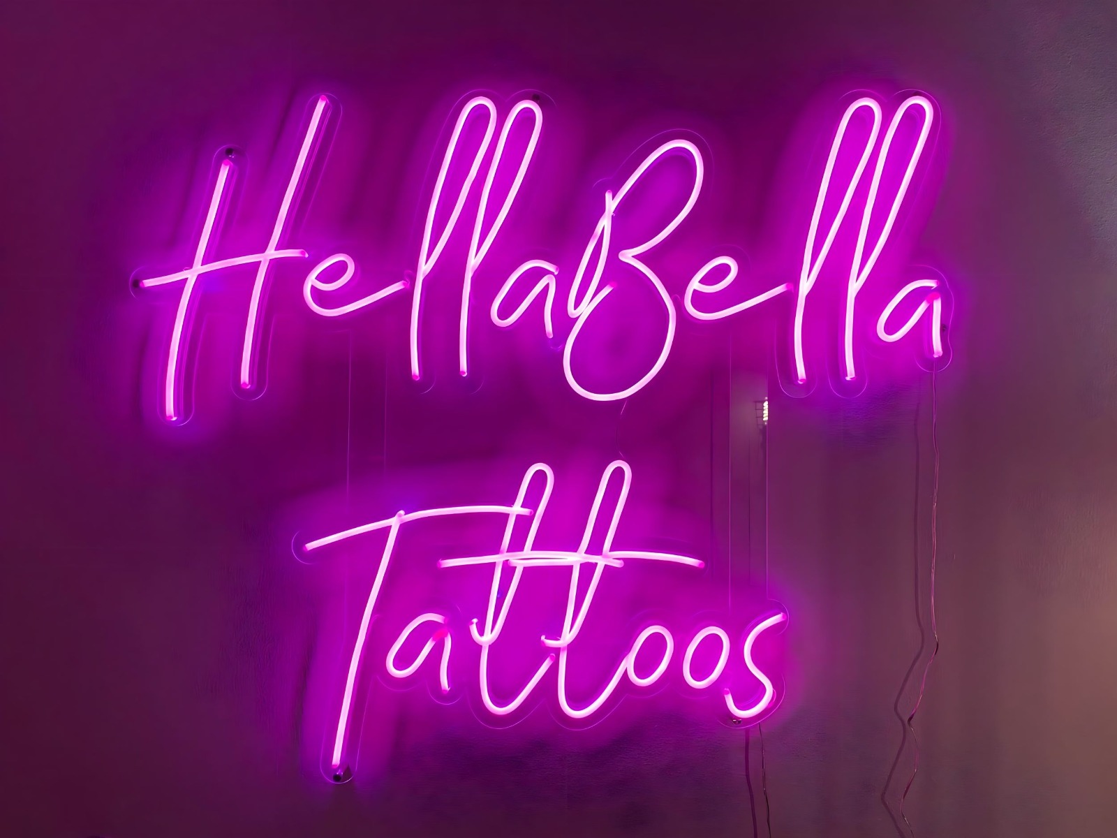 Large pink Custom Neon® tattoo artist sign @hellabellatattoos