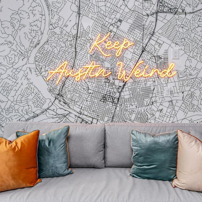 Keep Austin Weird orange LED Custom Neon® sign on a large wall map of the city in an Airbnb home designed by Somerled