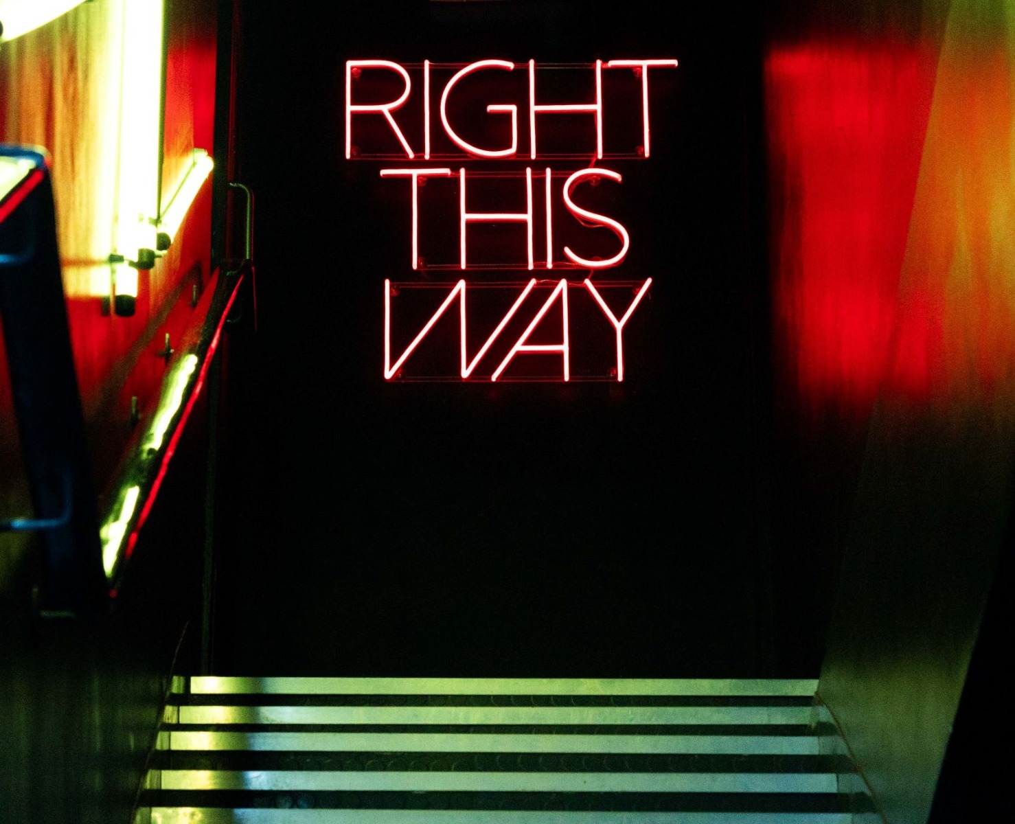 Right This Way red Custom Neon® wayfinding sign at the top of the stairs @marketplaceofficial