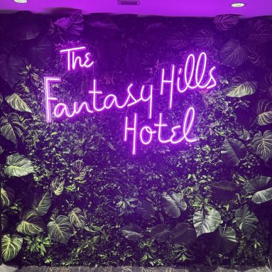 Hotel lobby purple LED neon sign in a script font