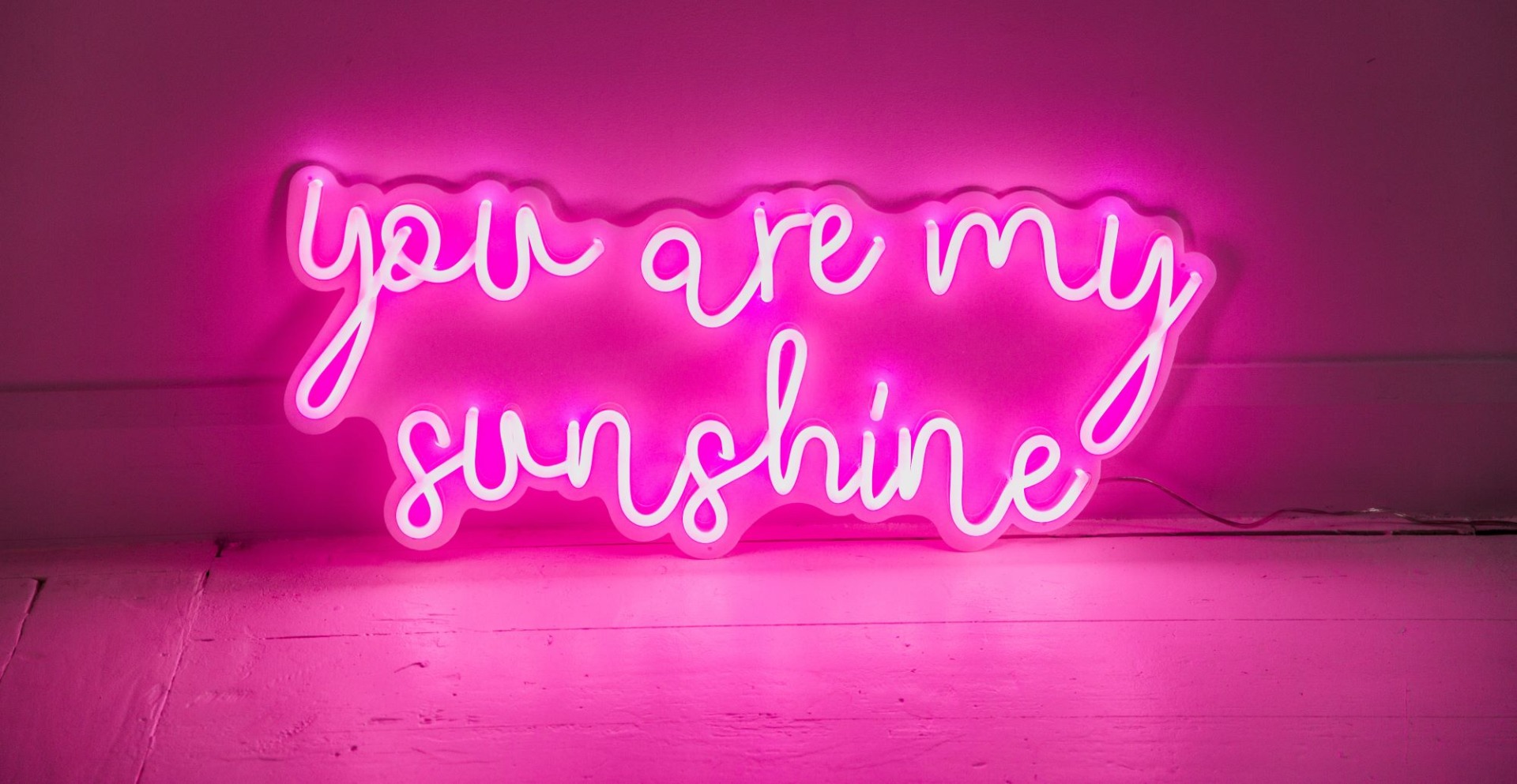 You Are My Sunshine Custom Neon® sign in pink LED flex on a white acrylic backboard